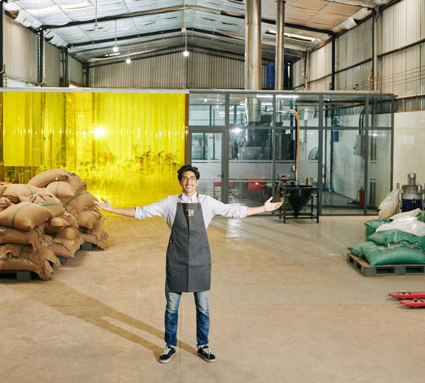 man standing in roastery space to show how Coffee Equipment Pros can help fill his roastery with the roaster and roasting equipment he needs