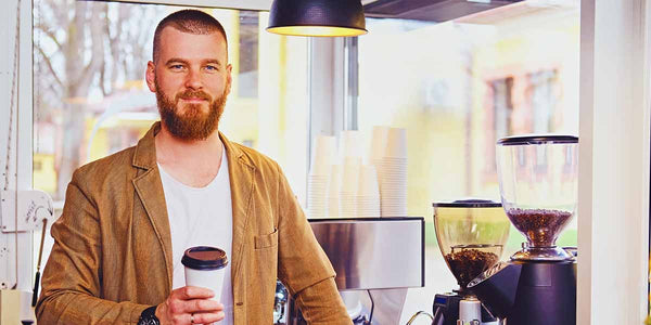 roastery shop worker standing at counter to represent Coffee Equipment Pros' buyers guide directory