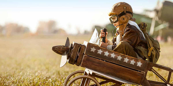 young boy in a wood crate airplane at top of Coffee Equipment Pros' equipment request form symbolizing that we support the lookers and dreamers