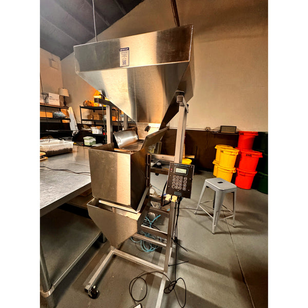 Right-side view of a 2024 Logical S-4 used coffee weigh-and-fill machine showing the feed tray, controller and frame.